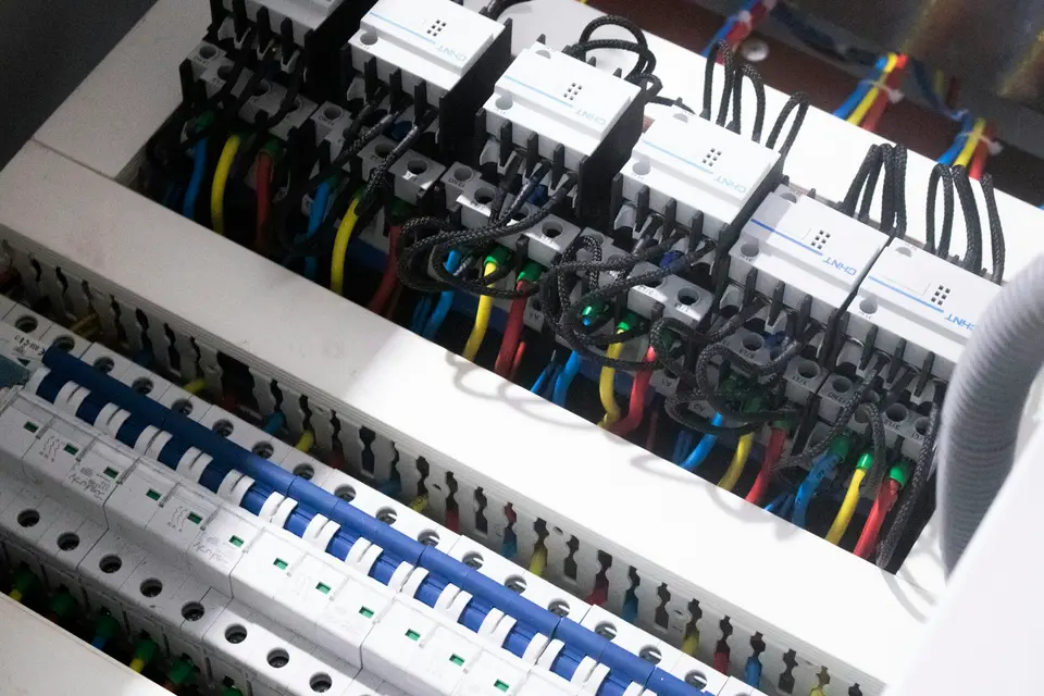 Een open groepenkast met installatieautomaten en gekleurde draden
